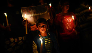 People pray for photojournalist Shiraaz Mohamed in Lenasia, South Africa