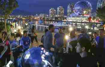 People touch interactive art device in Vancouver, Canada